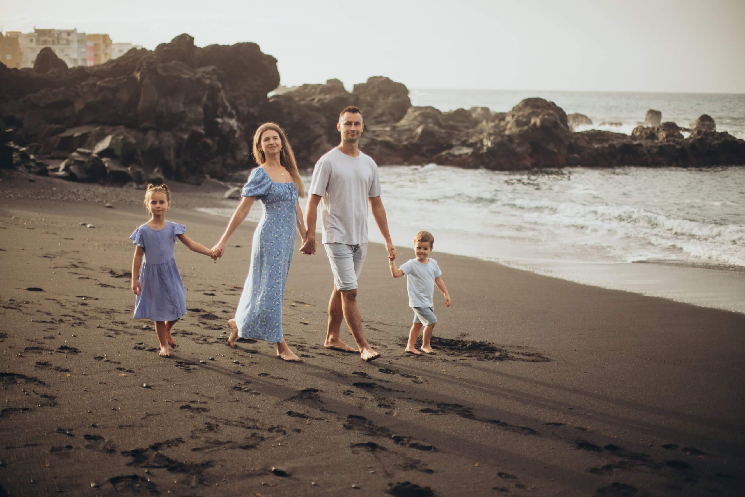 Junge Familie am Strand Junge Familie mit zwei Kindern, geht am Strand spazieren